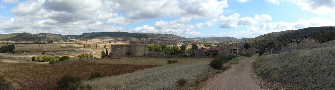 Vista de Palazuelos con el castillo y la muralla en primer plano.