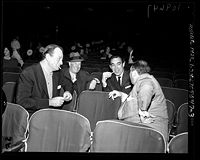 Jerry Wald (de espaldas a la cámara) durante los ensayos de los Premios Oscar de 1958, con John Wayne, Maurice Chevalier y Anthony Quinn