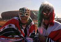 Aficionados de México con máscaras de luchadores a las afueras del Estadio Soccer City.
