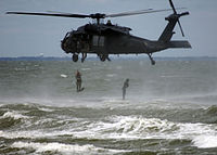 SEALs saltando al mar desde un helicóptero UH-60 Black Hawk