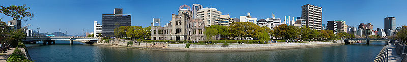 Vista de 180° del Parque Memorial de la Paz de Hiroshima. La Cúpula Genbaku, la cual permaneció en pie después del bombardeo, se ve claramente al centro de la imagen. El blanco original era el puente Aioi, a la izquierda en la vista panorámica.
